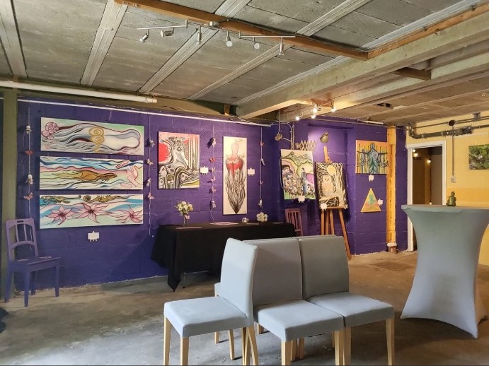 Les peintures d’Isabelle Jean sur un mur violet en exposition